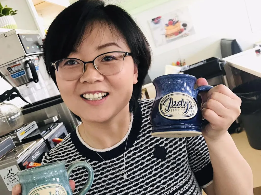 judy holding cafe mugs